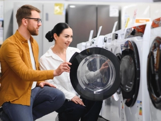 Young couple choosing washing machine in retail store