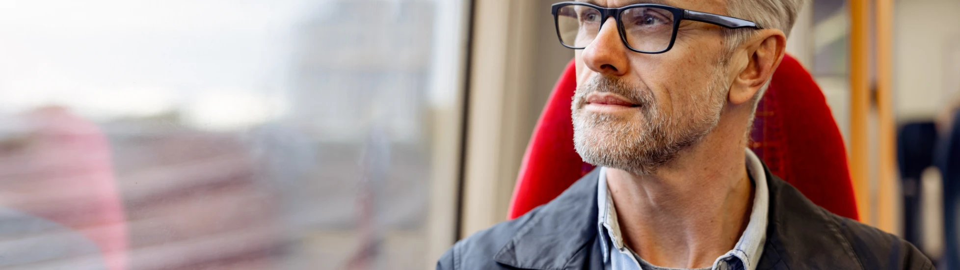 man on a train holding a mobile phone
