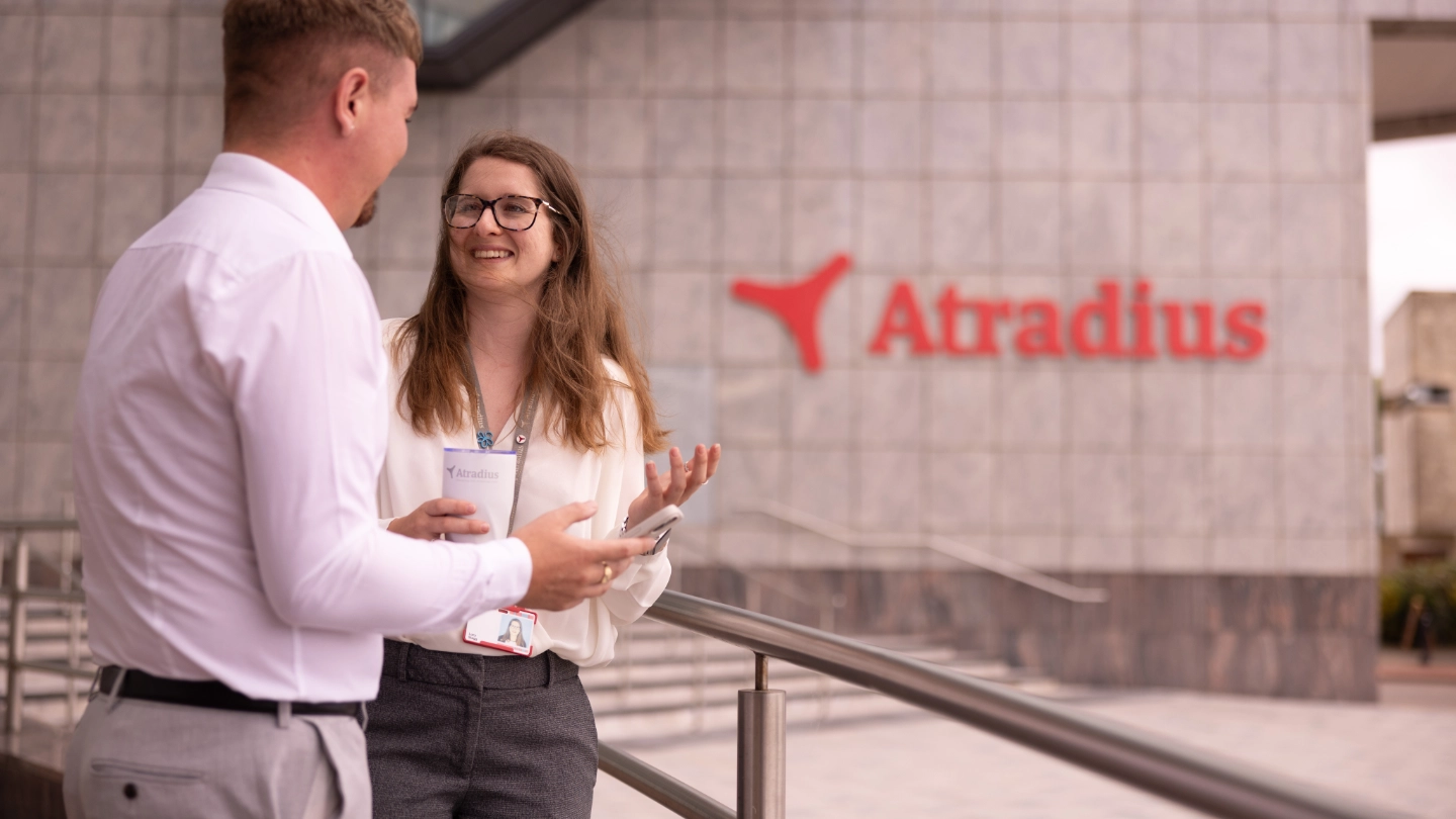 Woman and man have coffee break outside at the entrance of the Cardiff office Woman and man have coffee break outside at the entrance of the Cardiff office