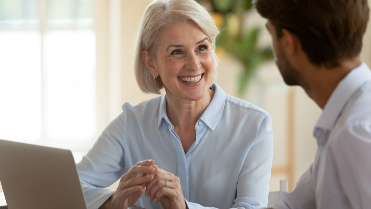 Middle aged woman talking to a male colleague