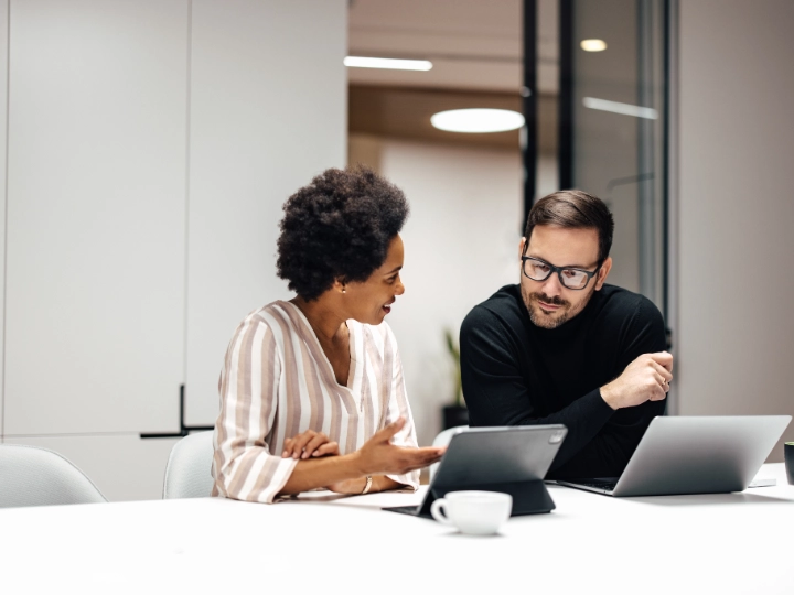 Man and woman looking at laptop screens
